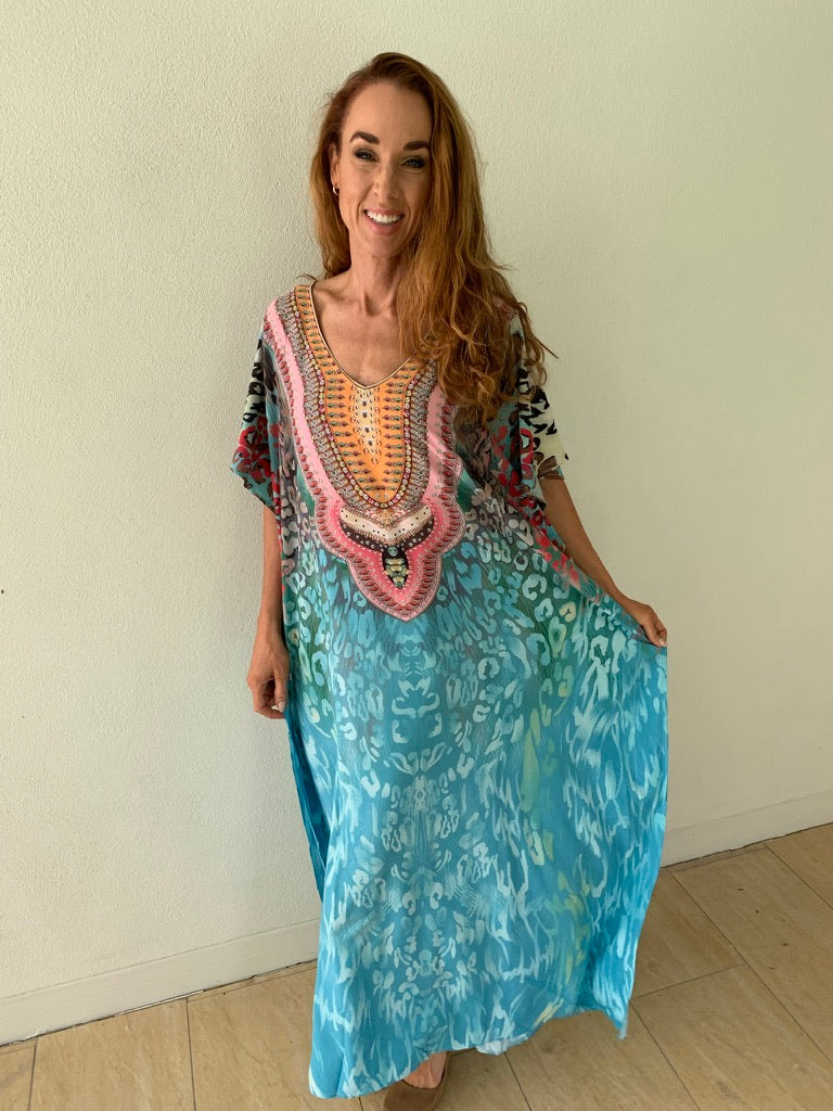 Lady in light blue kaftan with pattern around the neck with half long sleeves