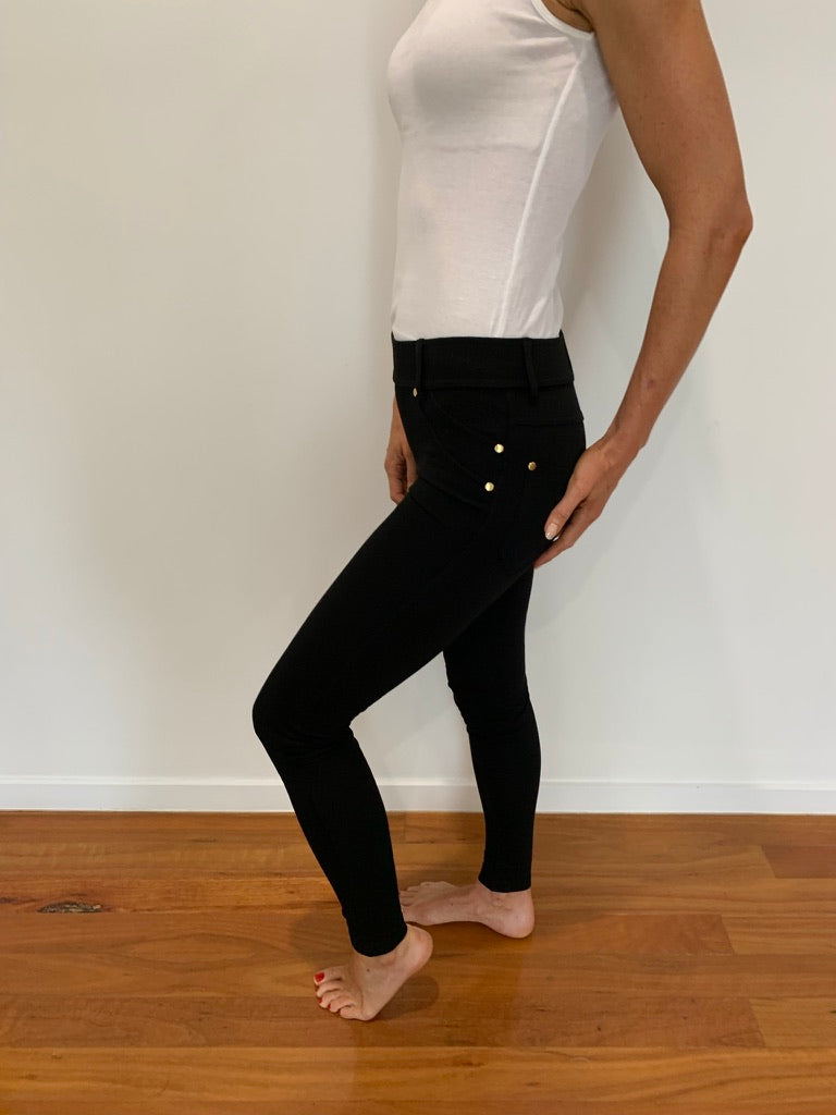 Lady in four way stretch black pants with gold buttons